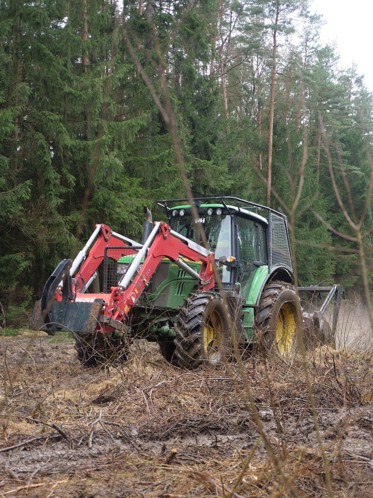 Lesní traktor s čelním nakladačem při úpravě pozemku